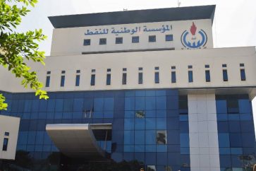 Onlookers gather in front of the headquarters of Libya's National Oil Company in the capital Tripoli on September 10, 2018. - Armed men stormed the building in Tripoli today where a blast and gunfire were heard, witnesses and a security source said. (Photo by Mahmud TURKIA / AFP)