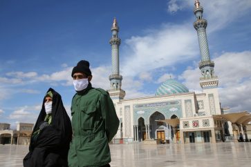 A couple wearing protective face masks, following the outbreak of coronavirus disease (COVID-19), walks on the street in Qom, Iran March 24, 2020. Picture taken March 24, 2020. WANA (West Asia News Agency) via REUTERS ATTENTION EDITORS - THIS PICTURE WAS PROVIDED BY A THIRD PARTY