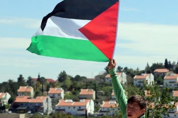 Drapeau de la Palestine brandi par un enfant en face des colonies israéliennes en Cisjordanie occupée (illustration)