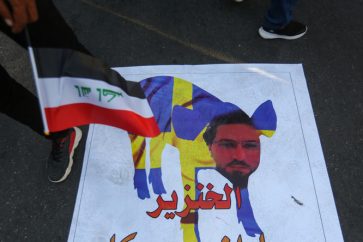 Un Irakien piétinant une illustration de Salwan Momika.