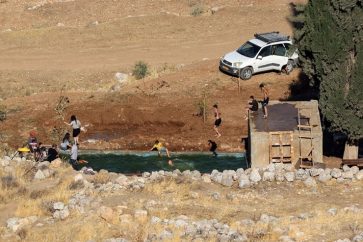 Des colons israéliens se baignent dans la source d'Ein Samiyah, près du village de Kafr Malik, en Cisjordanie occupée, le 15 juillet 2025.